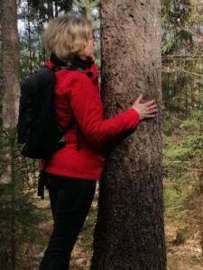 Energetikerin Claudia Ebner umarmt einen Baum